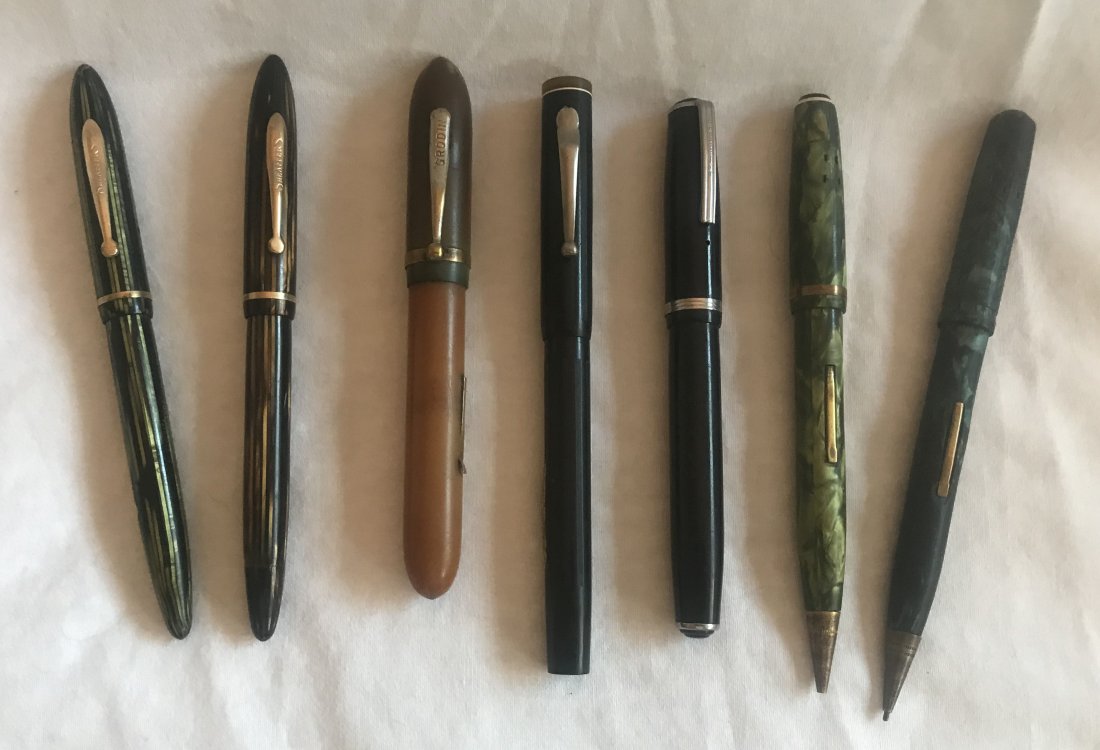 Grouping of Vintage Fountain Pens: Grouping of 7 vintage fountain pens, various colors in brown, black, green and blue, makers include Grodin, Sheaffers (2), Esterbrook, Belmont w/14K pen point tip, plus 2 others unmarked (both missing
