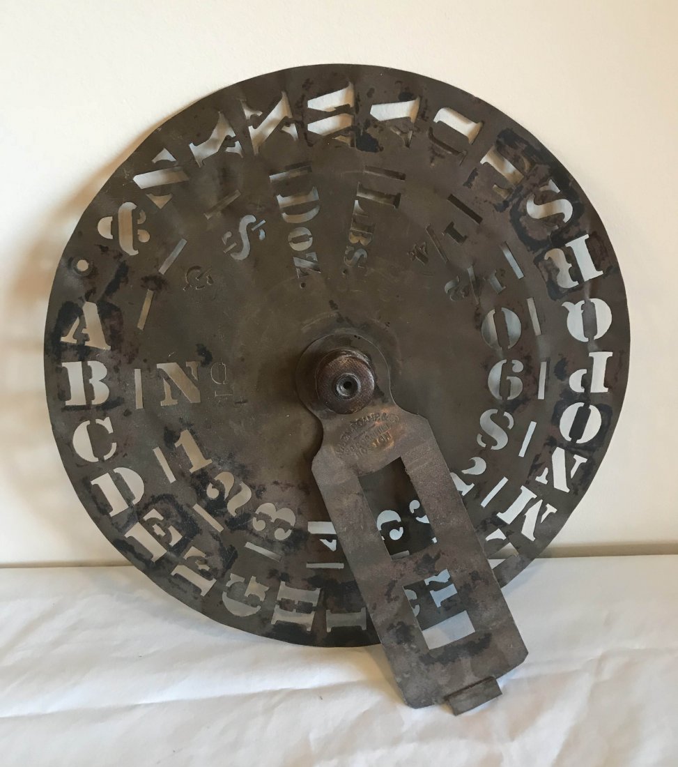 FURNITURE, ACCESSORIES, COUNTRY COLLECTIBLES, TOYS,: Vintage round brass stencil template with alphabet, numerals and other symbols, center wooden knob with adjustable piece marked Allen Doane & Co., Boston, 13 ¾” diameter