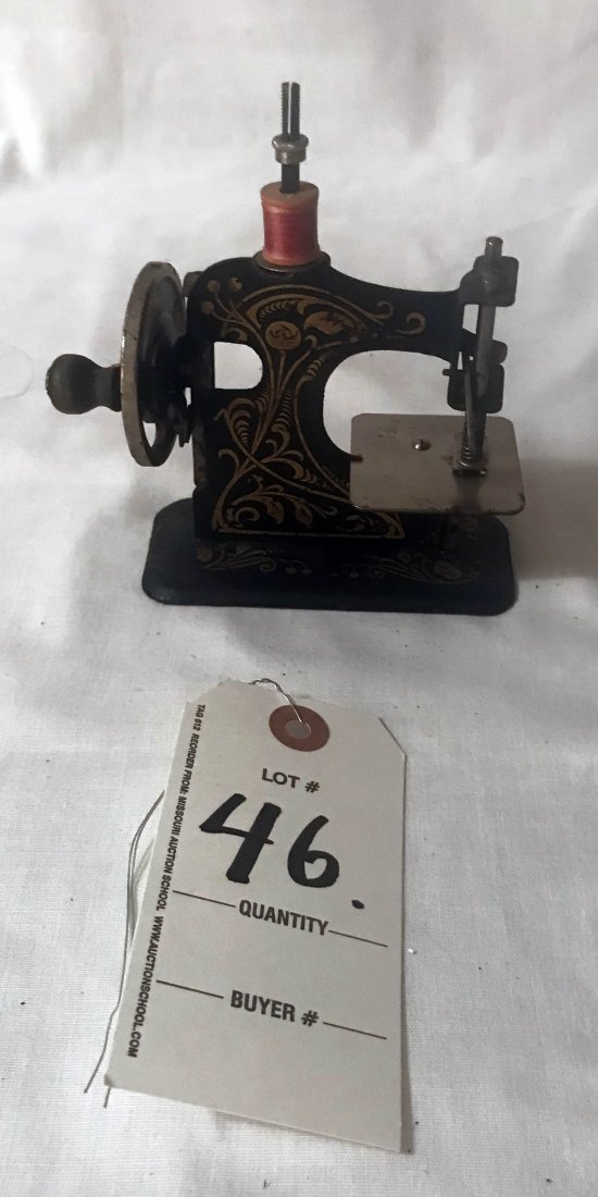 FURNITURE, ACCESSORIES, COUNTRY COLLECTIBLES, TOYS,: Toy sewing machine in black w/gold stenciled design, nickel plated mechanism, Made in Germany No. 205082, normal wear, tear, scratching and scuffing, 5 1/4" T x 4" W x 2" D