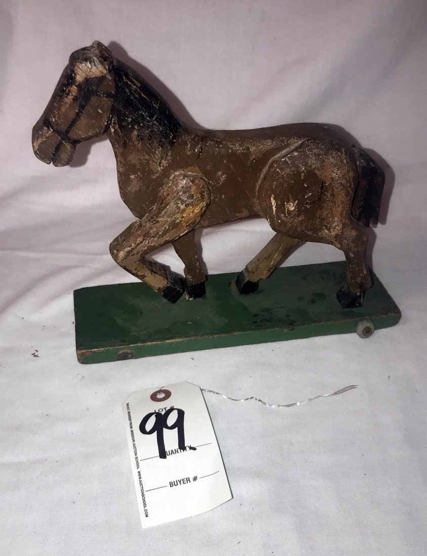 FURNITURE, ACCESSORIES, COUNTRY COLLECTIBLES, TOYS,: Primitive wooden folk art horse pull toy in dark brown paint w/black/brown mane and tail; wooden ears are very worn, on a base painted green w/small galvanized metal wheels-1 missing; original unresto