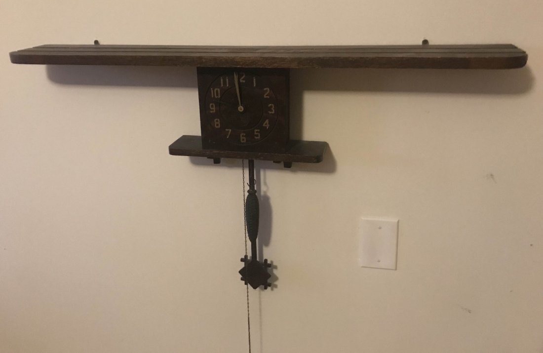 HANDCRAFTED JEWELRY, STERLING AND PLATED SILVER, CLOCKS: Early 20th century Mission oak wall clock, top shelf with groves for display items over a centered dial having Arabic numerals with small shelf, pendulum and 1 weight, old finish