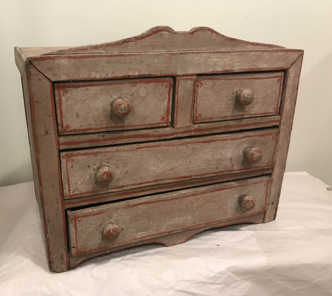 DOLLHOUSE, DOLLS, MINIATURES: Vintage country Victorian softwood doll size bureau having a cut out cornice over 2 short and 2 long crawers all w/wooden knob pulls,, dull pink painted surface w/red pinstriping, top of cornice missi