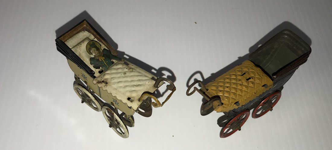 DOLLHOUSES, DOLLS, MINIATURES: 2 miniature doll carriages: 1 marked Germany with attached tin baby, baby dressed in blue with bonnet, carriage pale yellow with black hood and under carriage, star burst design, condition-shows sign 
