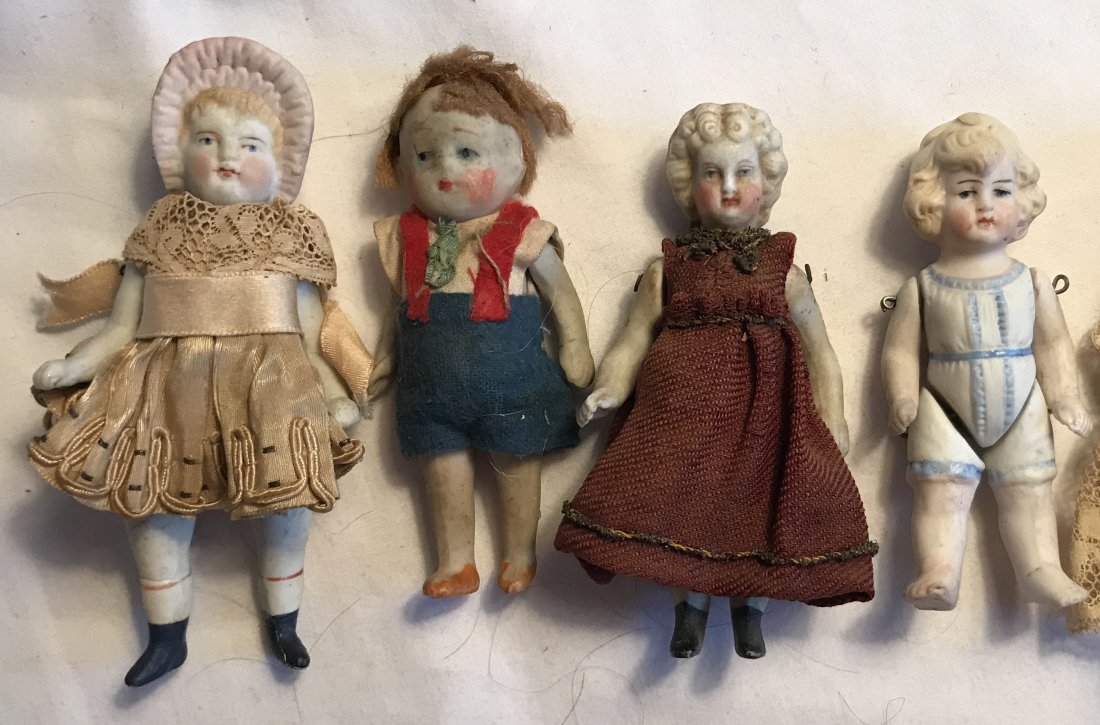 DOLLHOUSE, DOLLS, MINIATURES: Group of 4 miniature bisque dolls, all with handpainted features, some have movable arms and/or legs: girl having molded hat, silk dress with lace shawl, dress showing minor deterioration, some irregu