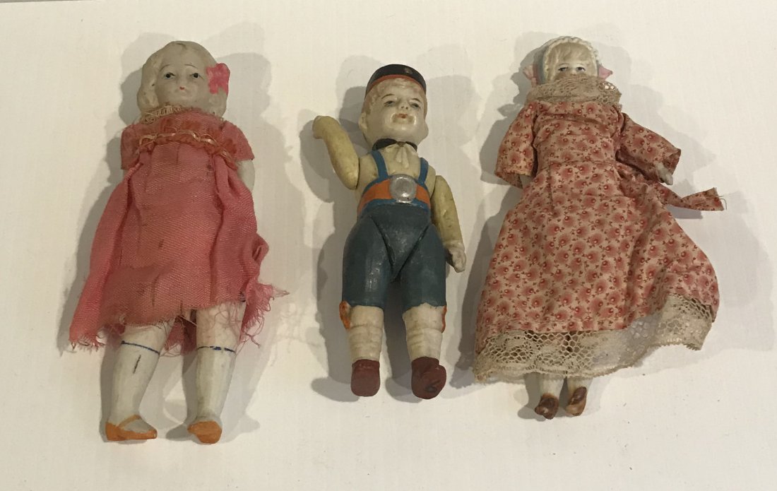 DOLLHOUSE, DOLLS, MINIATURES: Group of 3 bisque/porcelain dolls, all w/handpainted faces molded hair: girl w/blonde molded hair and bonnet, porcelain arms and legs, cloth body, pink floral dress, marked Germany, 6 1/4"; boy w/pain