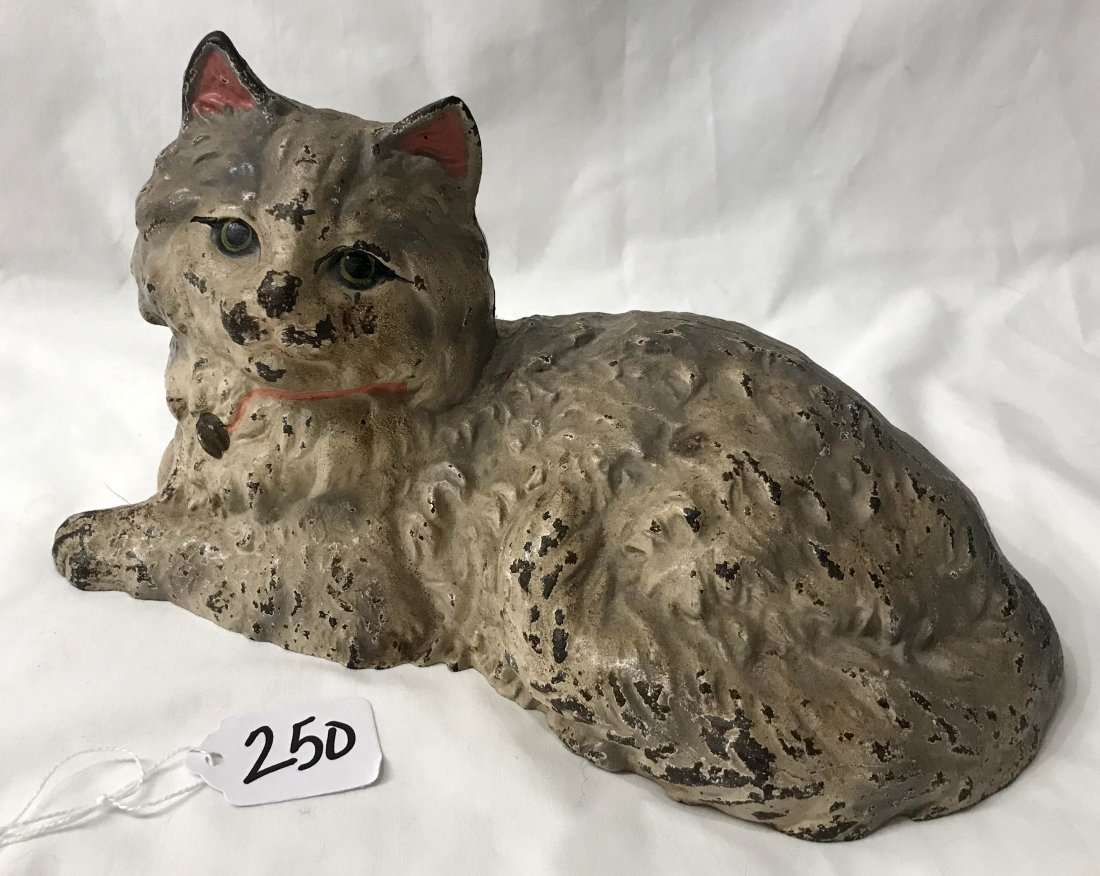 FURNITURE, ACCESSORIES, COUNTRY COLLECTIBLES, TOYS, ETC: Vintage cast iron doorstop cat figure marked Hubley w/handpainted in white and pink w/black and green eyes, surface shows old wear and paint loss throughout, 5 3/4" T x 10" L x 5 1/2" D