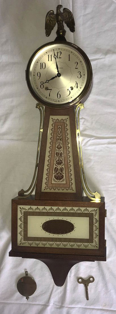 HANDCRAFTED JEWELRY, STERLING AND PLATED SILVER, CLOCKS: Older reproduction banjo clock by Seth Thomas made in USA, mahogany case w/eagle finial, reverse painted glass panel on trunk, base door, brass eagle finial, complete w/key and pendulum, 8 day time an