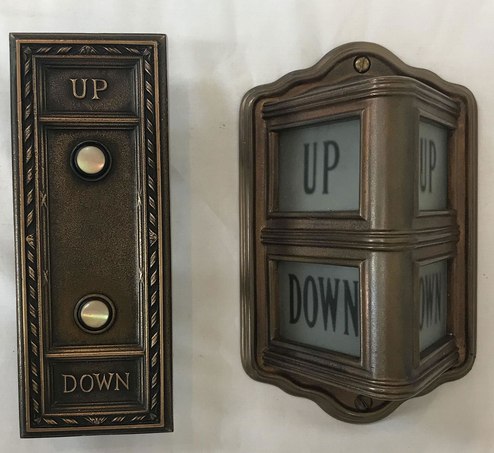 (2) Vintage Elevator Signs: Vintage wall mounted bronze tri-corner elevator UP/DOWN signal w/back plate, cast iron back, electrifed, 8 3/4" T x 5 1/4" W x 3 3/4" D AND a bronze wall mounted elevator UP/DOWN switch w/mother of pe