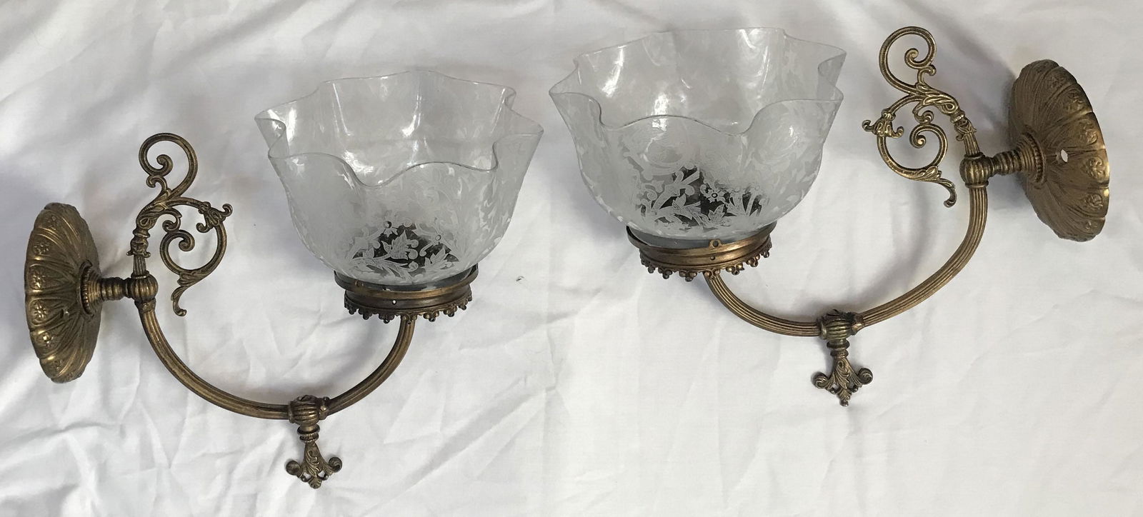 Pair of Gas Lighting Fixtures: Pair of ornate brass wall mounted gas lighting fixtures, curved reeded arms w/base turning handles, etched clear glass shades w/ruffled rims floral design, have been electrified, missing several screw