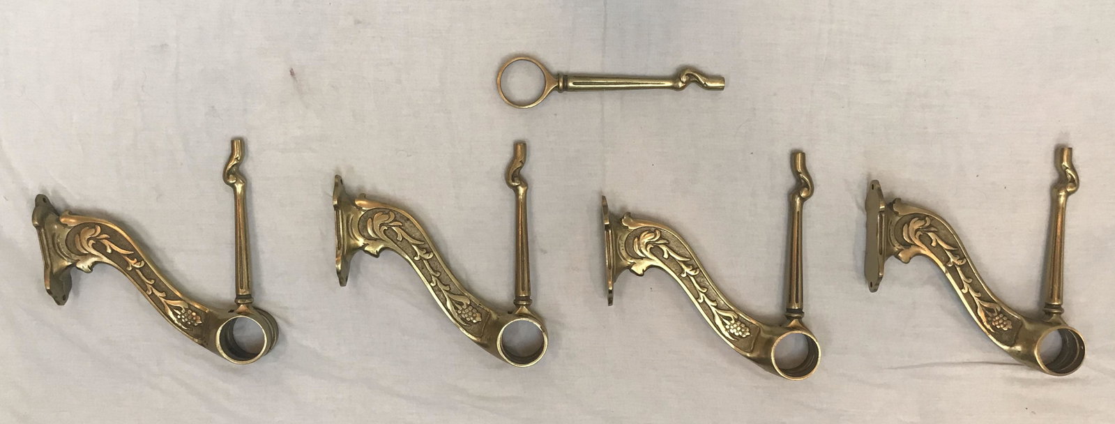 Set of Brass Bar Rail Brackets: Set of 4 brass bar rail brackets w/leg extensions, berry and leaf design, leg extensions have tapered, fluted columns (w/2 extra leg extension); each approx. 9" T x 1 5/8" W x 8 3/4" D; total wgt. app