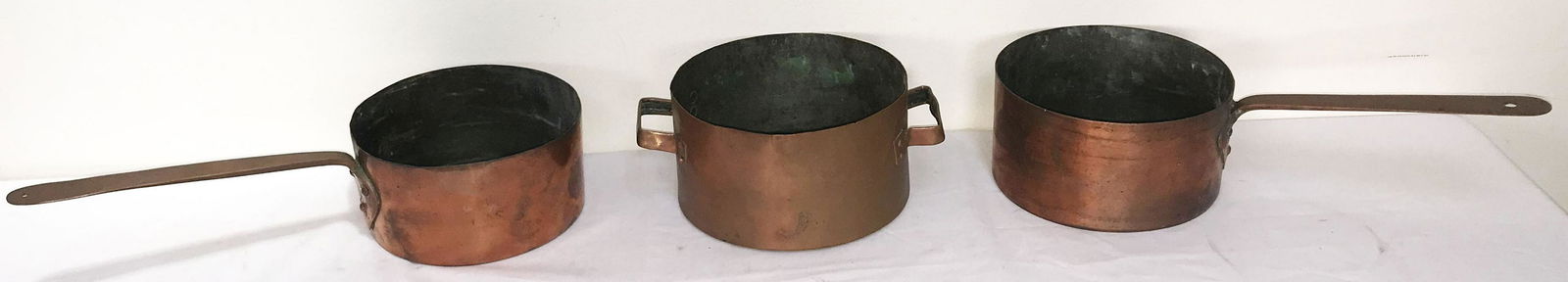 3 Vintage Copper Pots: Grouping of 3 vintage copper pots w/handles, dovetailed contruction: 1 w/applied handle w/heart shaped design, 4 1/8" T x 7 3/4" diameter, handle-9 3/8" L; 1 w/applied heart shaped handle, 3 7/8" T x