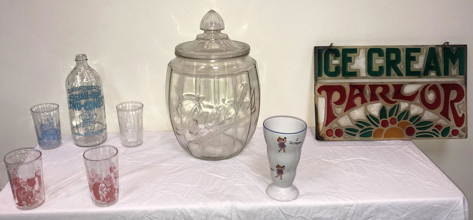 Grouping of Advertising Pieces: Vintage clear glass advertising store jar w/lid, barrel form design, marked Beich's, base shows some old wear, approx. 14" T x 8 1/2" diameter; clear glass advertising bottle "Cooling Sno-Cones" the s