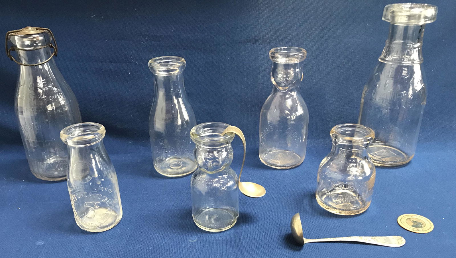Grouping of Milk Bottles/Dairy Collectibles: Grouping of 11 milk bottles/dairy collectibles: "Cop The Cream" cream top 1 pint milk bottle Glenside Dairy, Deep Water, NJ, 7 3/8" T; half pint cream top bottle Brookfield Dairy, Hellertown, PA, 5 3/