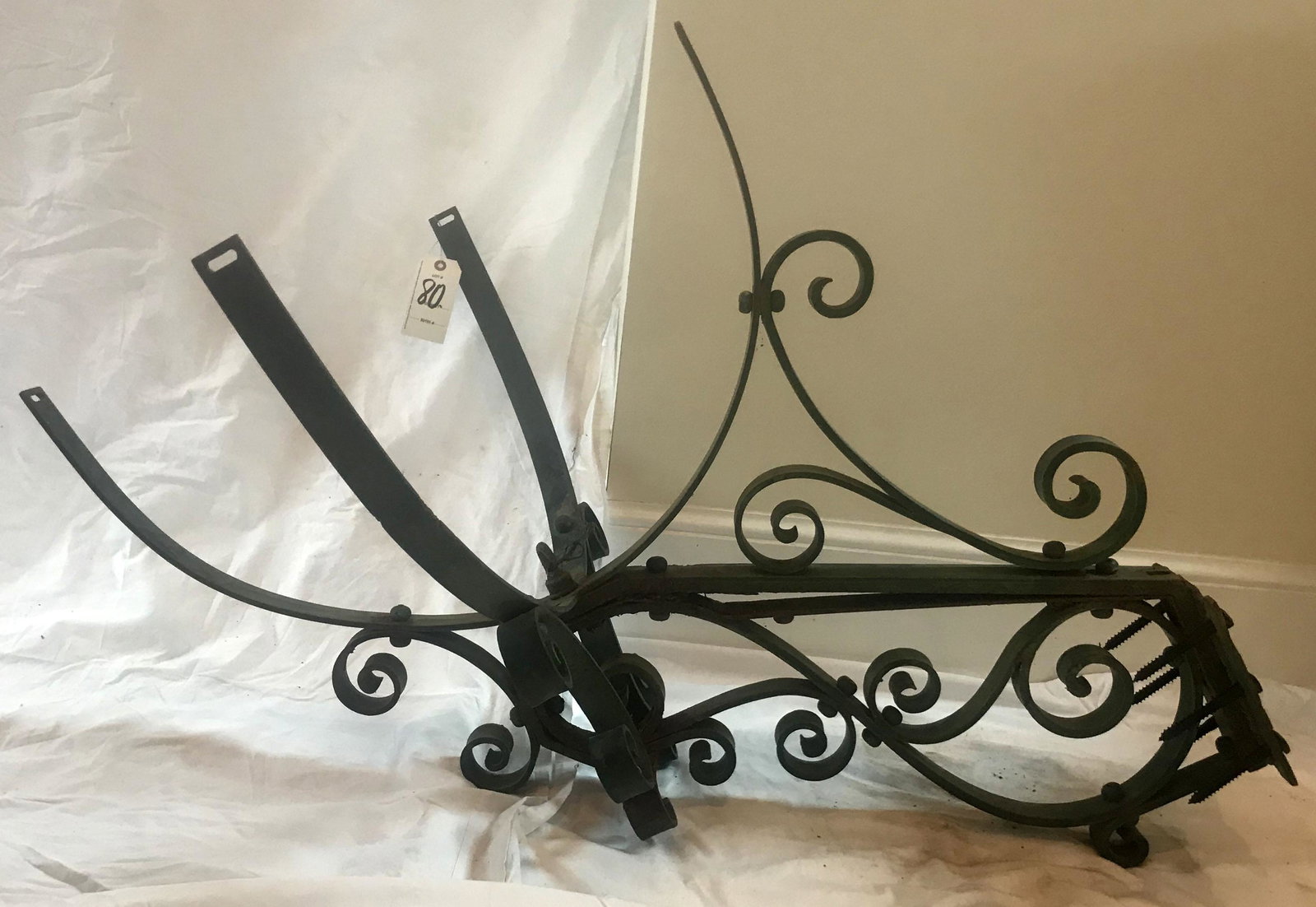 Antique Wrought Iron Lamp Bracket: Large antique wrought iron exterior wall mounted lamp bracket, scrolled design, old greenish/weathered surface w/old wear, rust and scratches visible, 4 curved arms w/old wiring and holder, approx. di