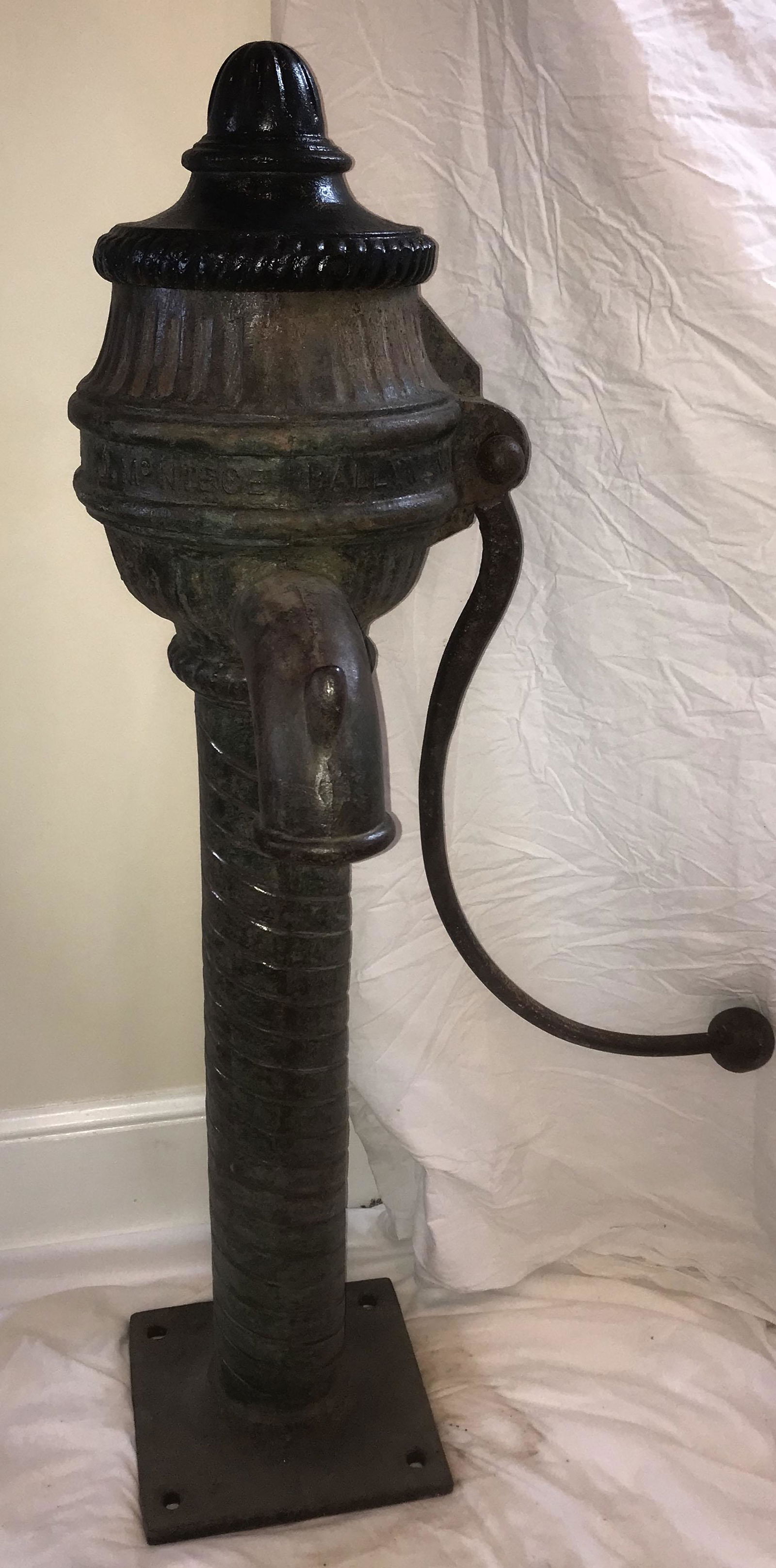 19th C Cast Iron Well Water Pump: 19th century cast iron well water pump w/removable urn form cap, ribbed, spiral column ending on square plate (has holes for bolts), curved handle w/ball shaped grip, curved spout w/bucket holder, fou