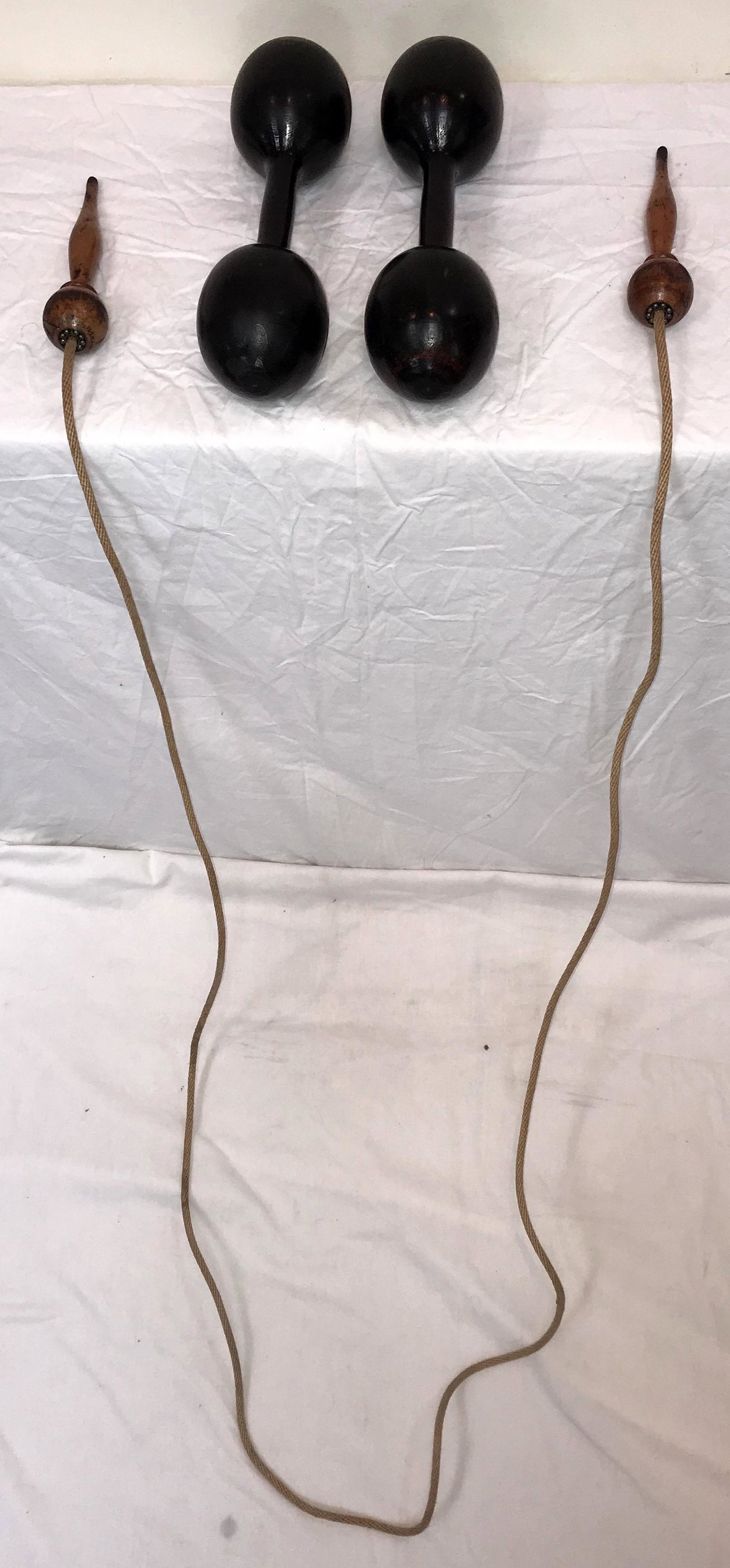 Jump Rope and Spalding Dumb Bells: Jump rope w/wooden handles made by The Veloscity Ball Bearing Skipping Rope patented 6480, turned wooden handles, probably maple, old original surface wear and patina, 118" total length AND (2) Spaldi