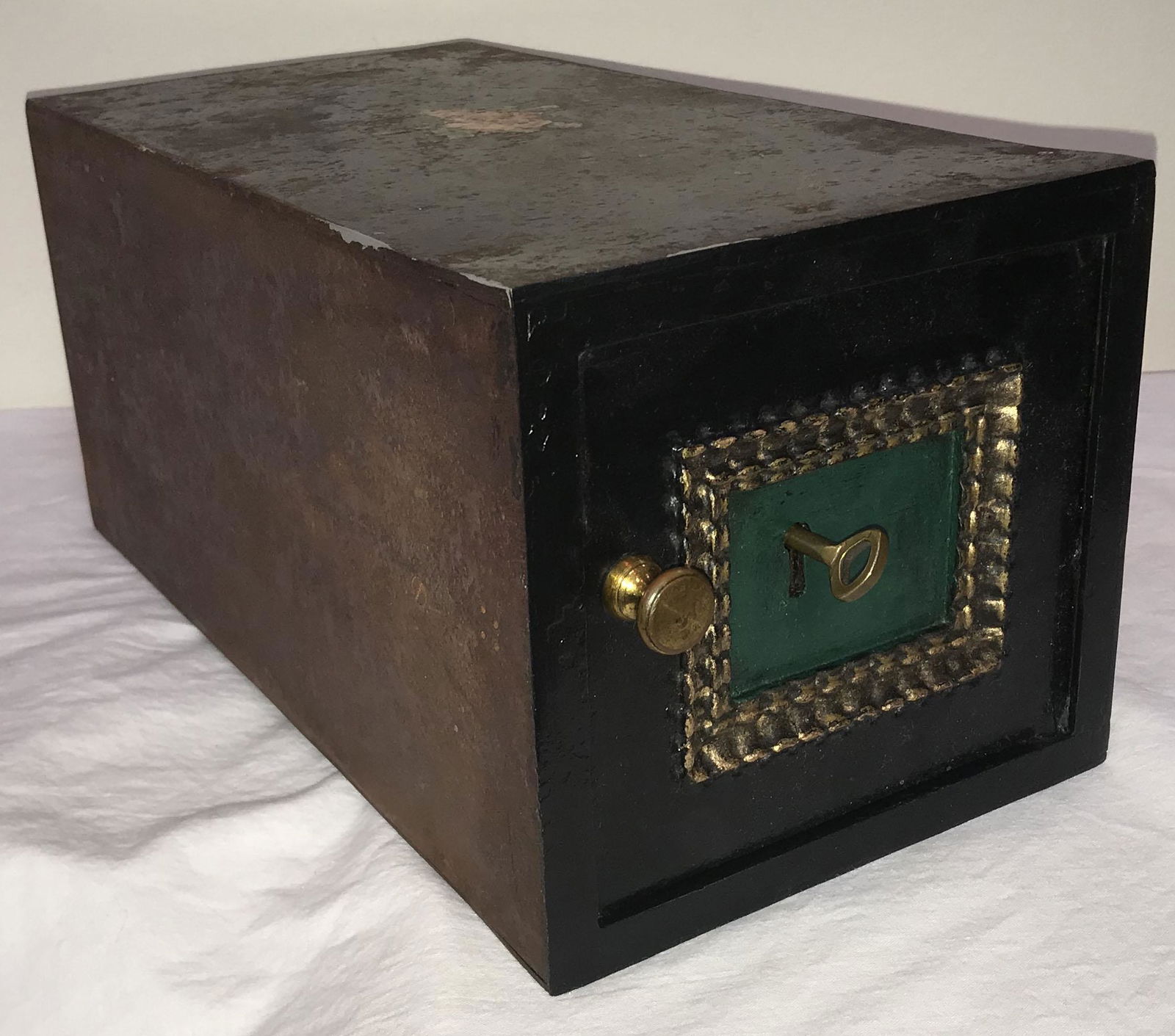 Small Cast Iron Safe: Small cast iron safe, door w/brass knob and key lock, keyhole escutcheon surrounded by a gold painted "frame", door, front and top painted black, sides, back and base unpainted showing old surface wea