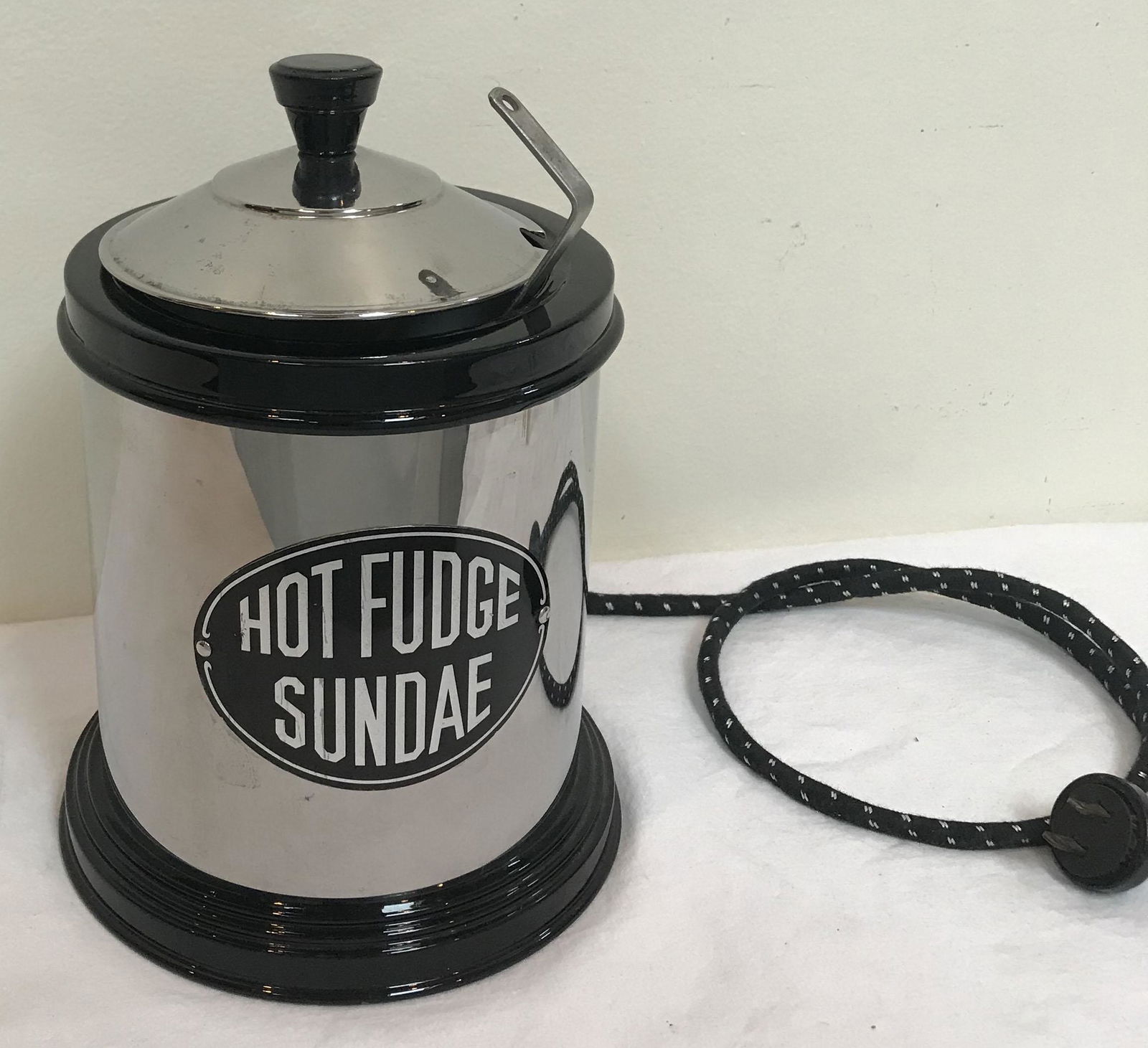Vintage Hot Fudge sundae Pot: Vintage electrified Hot Fudge Sundae pot, chrome plated pot and metal lid w/black finial, interior liner made of white glazed pottery, includes ladle, old style cord and 2 prong plug, 9 3/8" T x 6 3/4