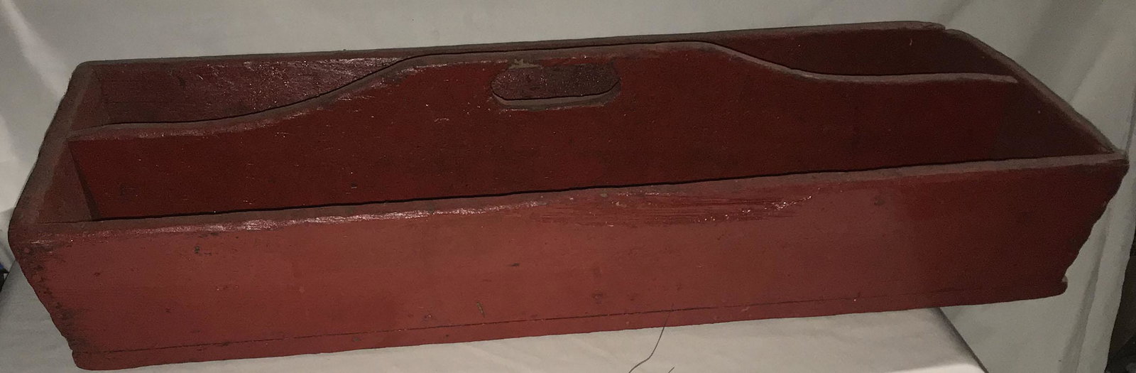 Country Wooden Toolbox: Primitive country wooden toolbox, painted red, center handle w/oval cutout, joints w/round nailes, well worn condition w/discoloration, scratches and some wood chipping, 7 1/4" T x 31 1/2" W x 12 5/8"