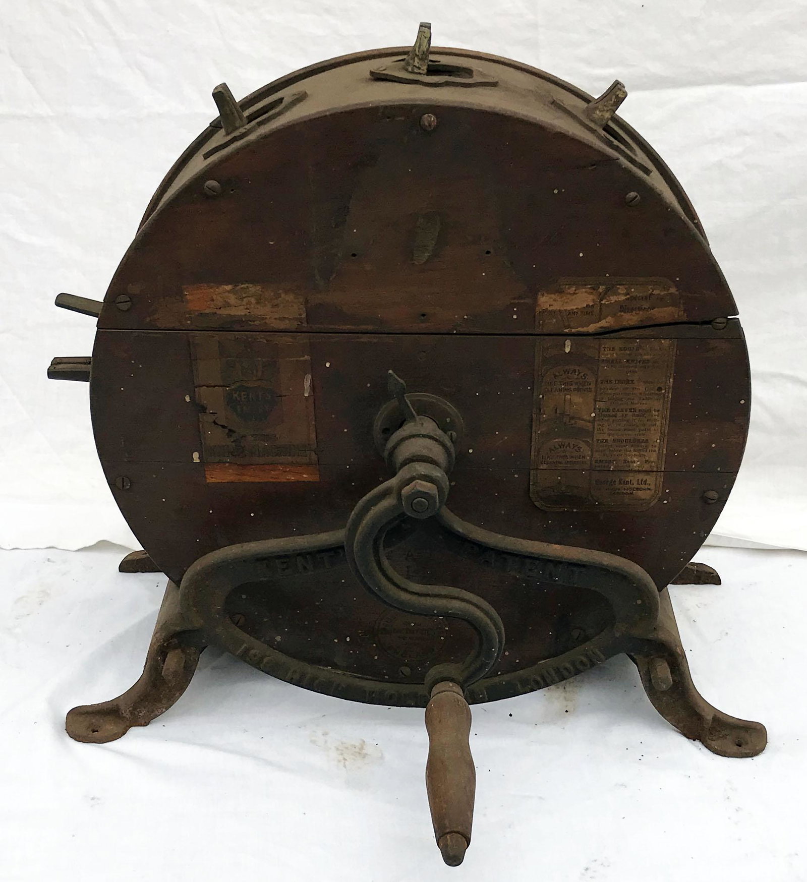 Antique Knife Sharpener: Antique circular knife sharpener w/old paper labels marked Kent's Emery Knife machine, wooden case mounted on cast iron base w/crank marked Kent's Patent 199 High Holborn London, wooden case stamped M