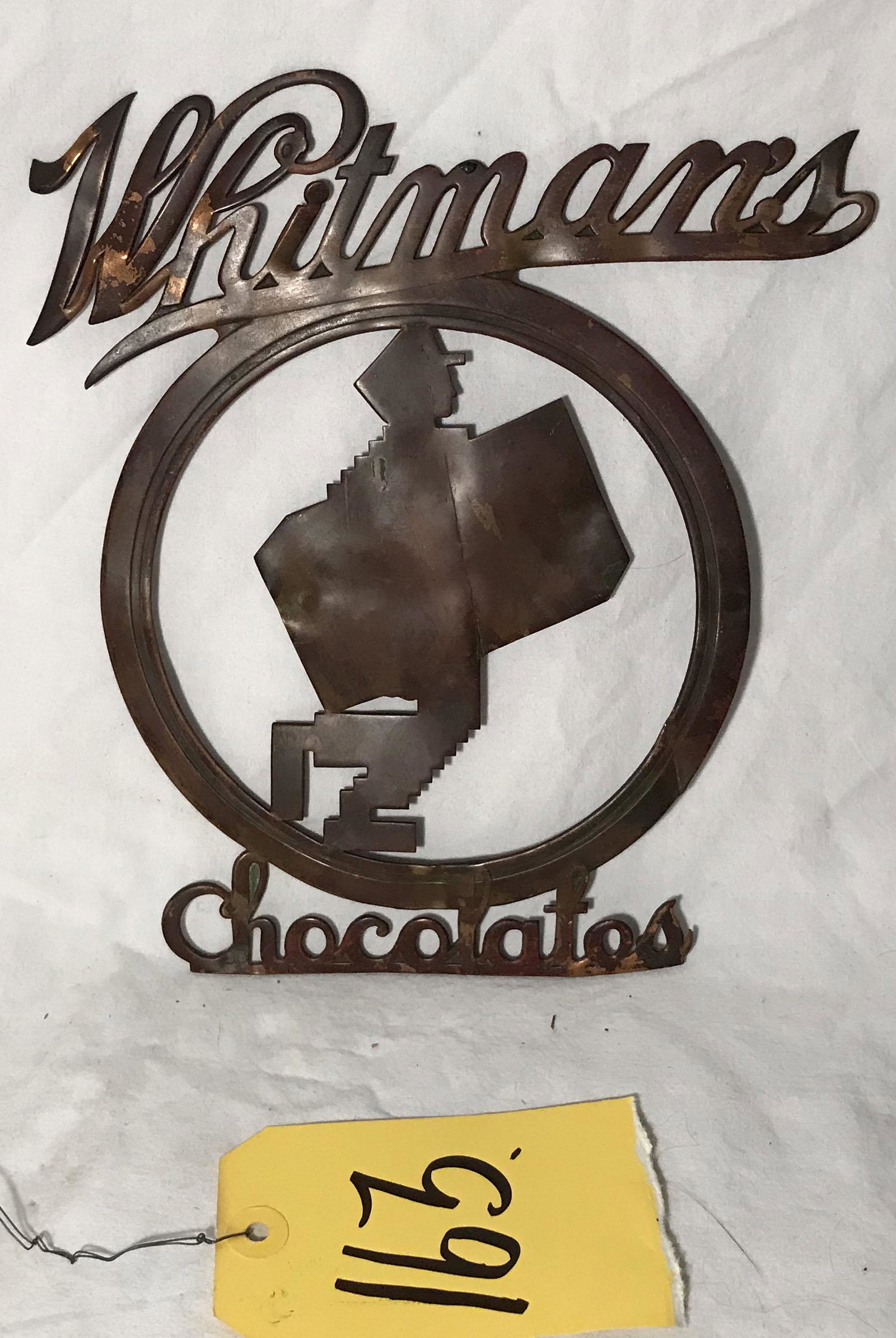 Vintage Whitmans Chocolate Sign: Vintage Whitmans Chocolates copper sign, showing wear, minor dents, creases, rust and discoloration, 9 1/4" T x 8 3/8" W (at Whitmans); circle-6 5/8" diameter