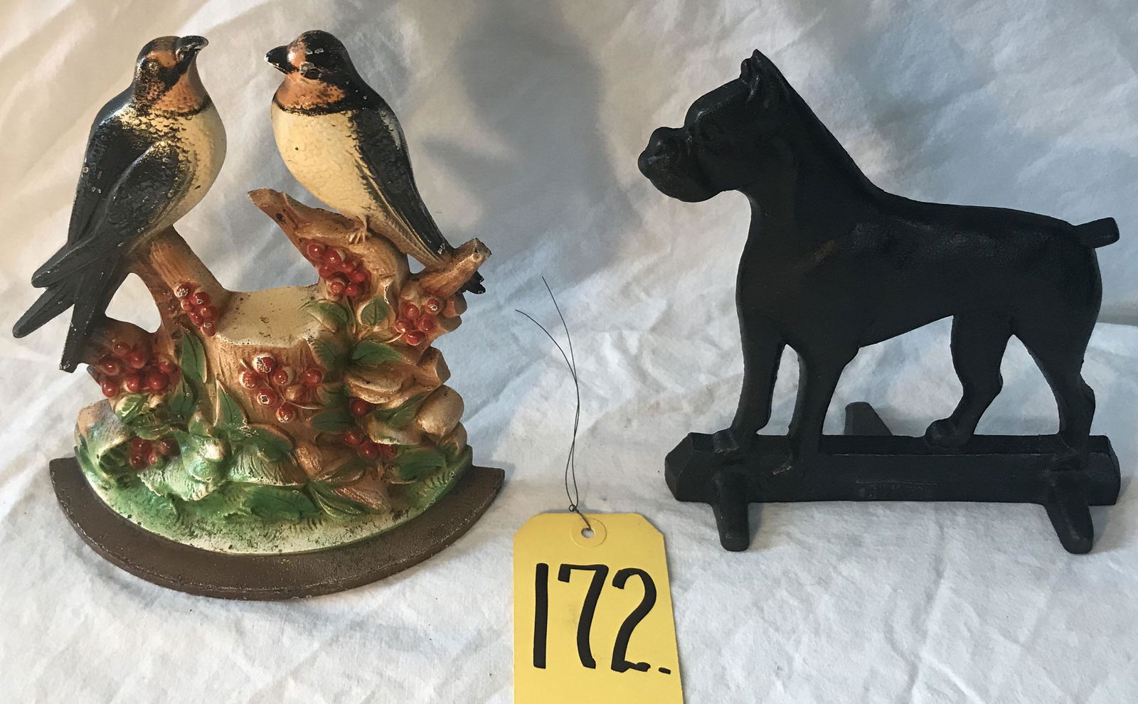 2 Cast Iron Doorstops: (2) figural cast iron doorstops: (1) w/2 birds perched on holly berry branches w/foundry mark 480 (similar to Hubley Swallows w/Holly red berries .. Hubley name not found), paint shows normal wear and