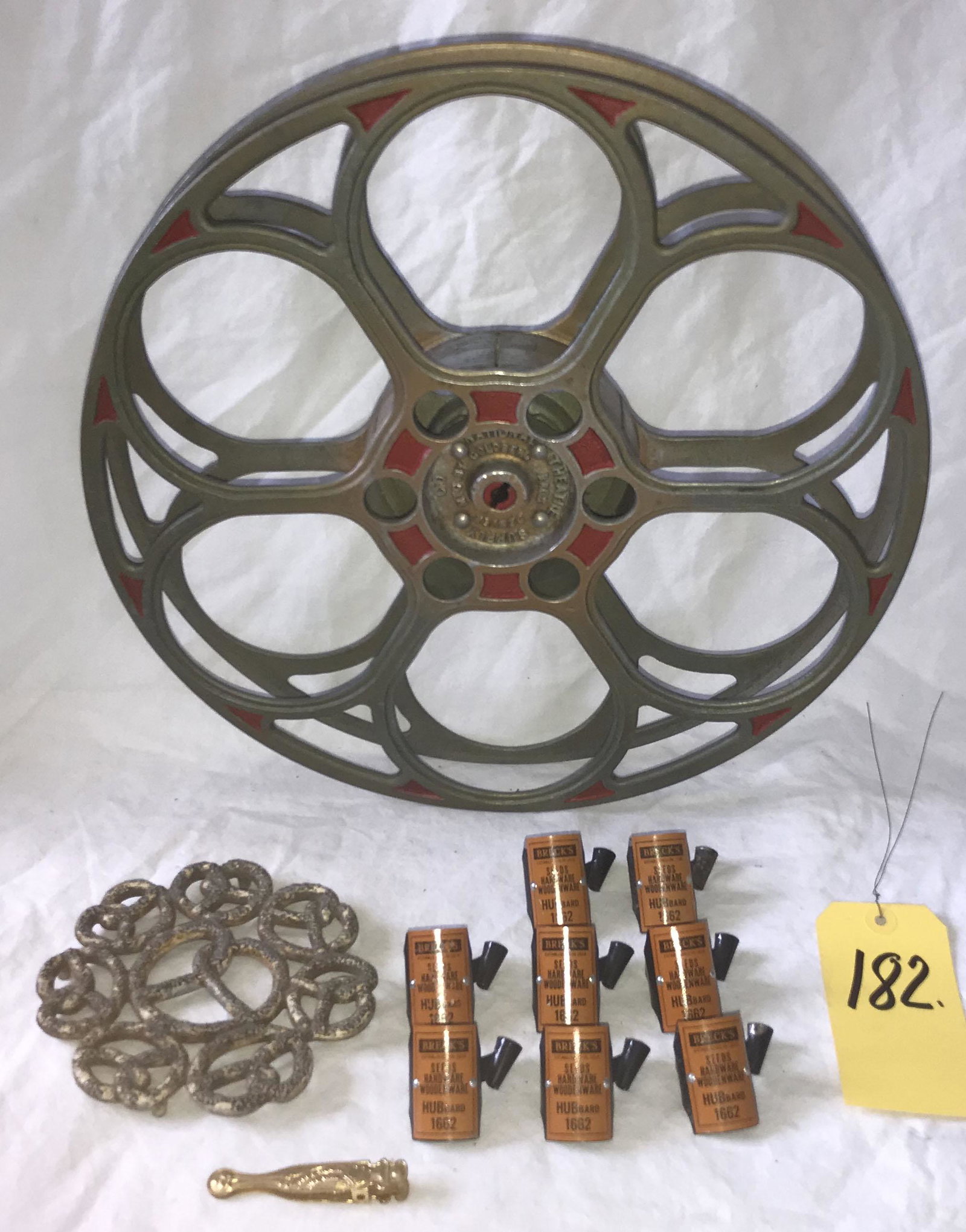 Grouping of Advertising Pieces: Grouping of advertising pieces: 4 footed trivet w/pretzel motif marked on back Lititz PA Home of the Pretzel, probably aluminum, old surface wear, 6" x 5 3/4"; small brass clip w/fluer de lis type end
