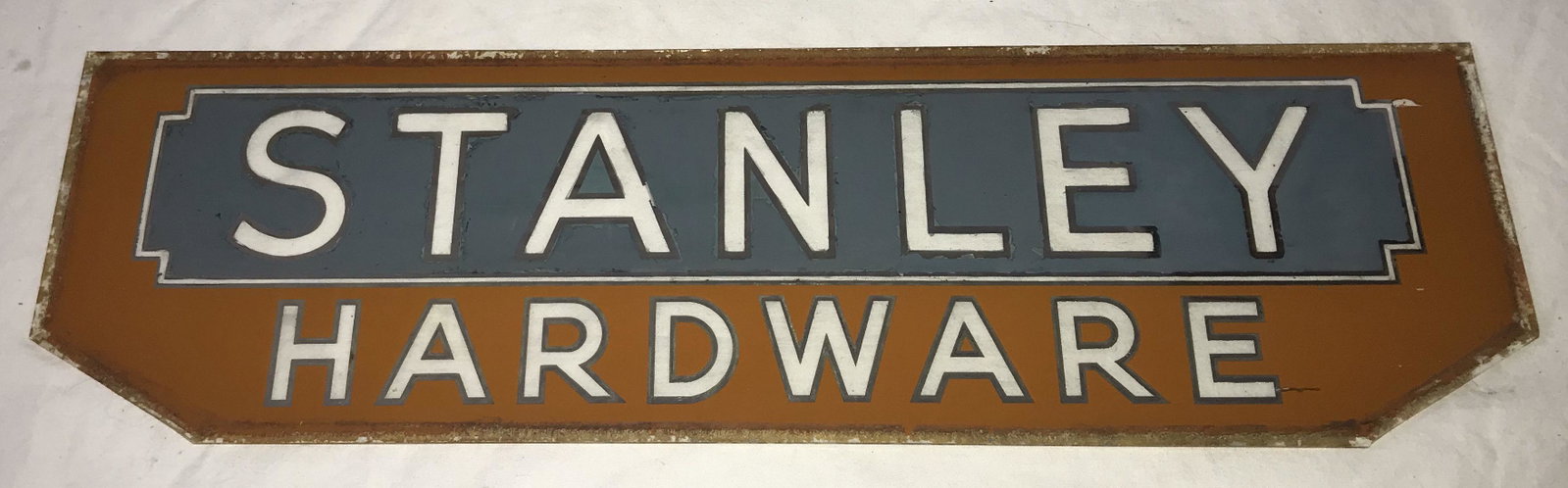 Vintage Sign for Stanley Hardware: Vintage glass advertising sign insert for Stanley Hardware, letters outlined in gold on blue and dull orange background, old wear and paint loss visible throughout, reserve side painted black, 5 3/8" 