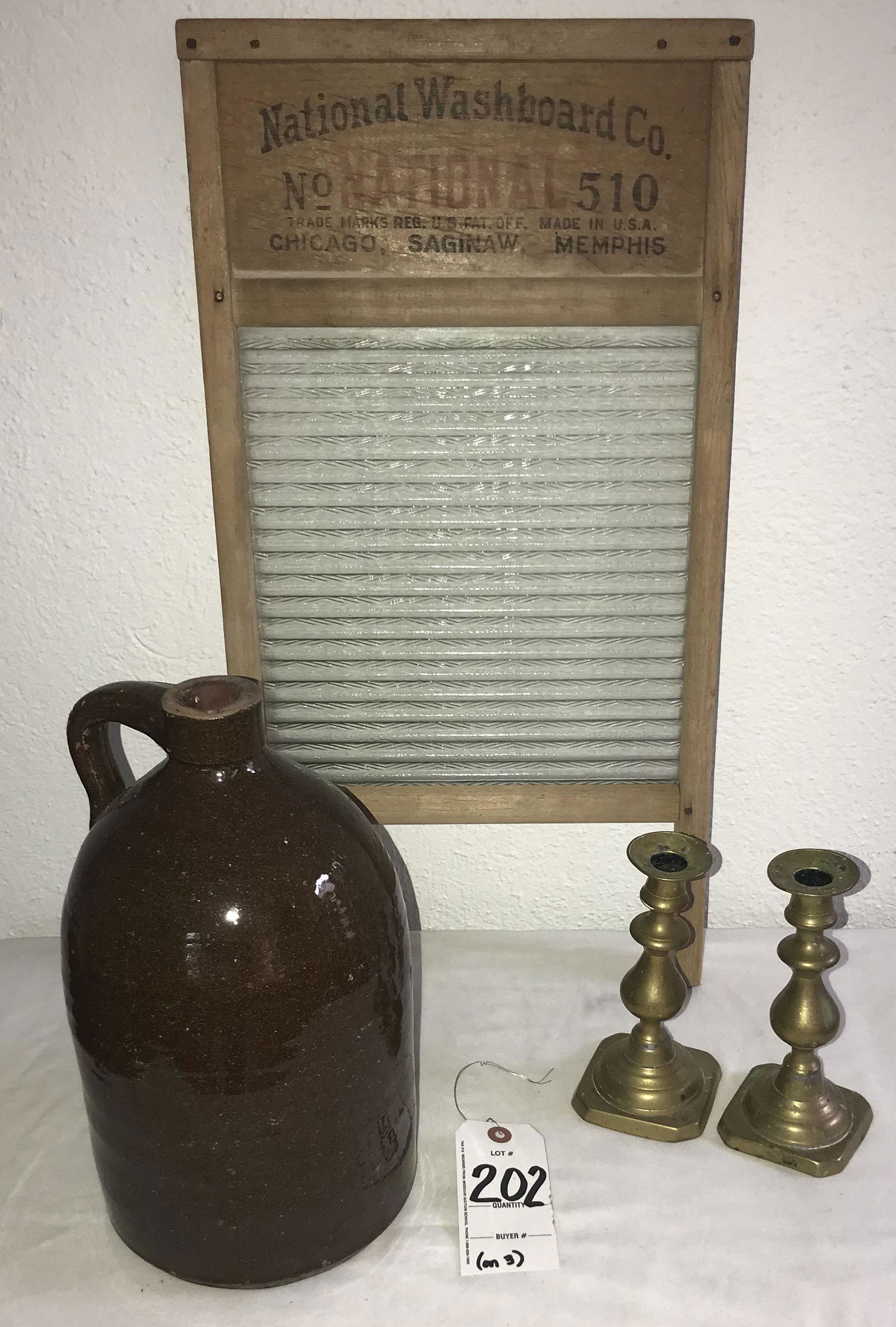 Redware Jug, Brass Candlesticks, Advertising Washboard: Country Collectible Group: Redware jug w/handle, dark brown glaze, normal age wear, chipping and minor roughness 12 1/2" T x 7" base diameter; pair of antique brass push up candlesticks on octagonal b
