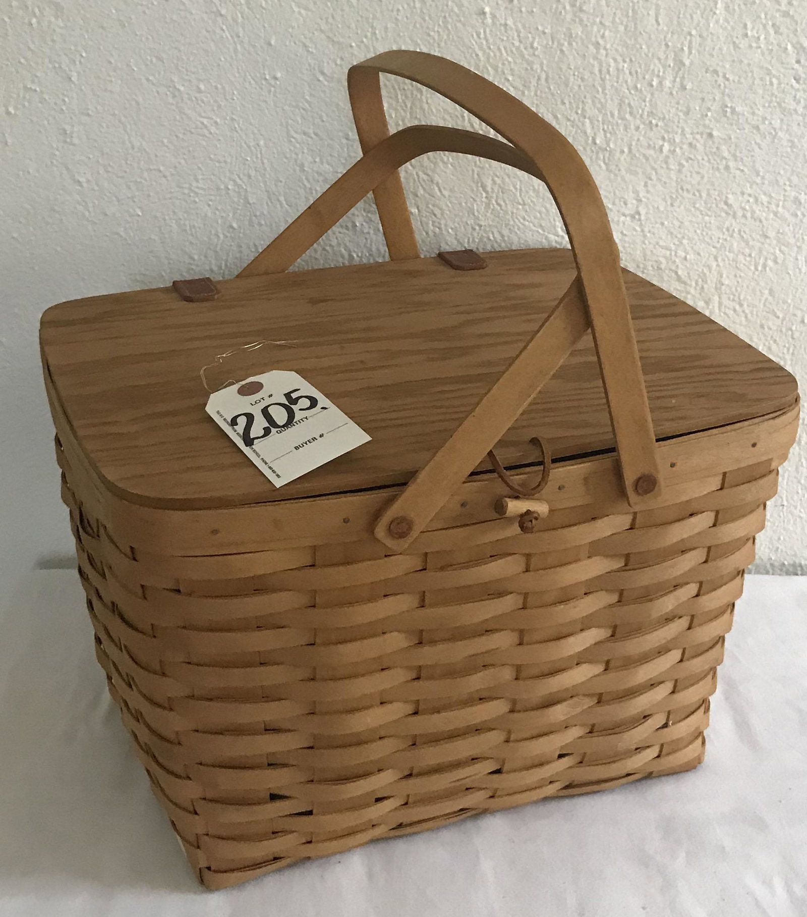 Longaberger Picnic Basket: Large Longaberger splint picnic basket w/2 handles, lid w/leather hinges, Longaberger mark on base, initialed and dated NIM 2004, original plastic liner, 10 3/4" T w/o handles x 16 1/2" W x 13 1/4" D