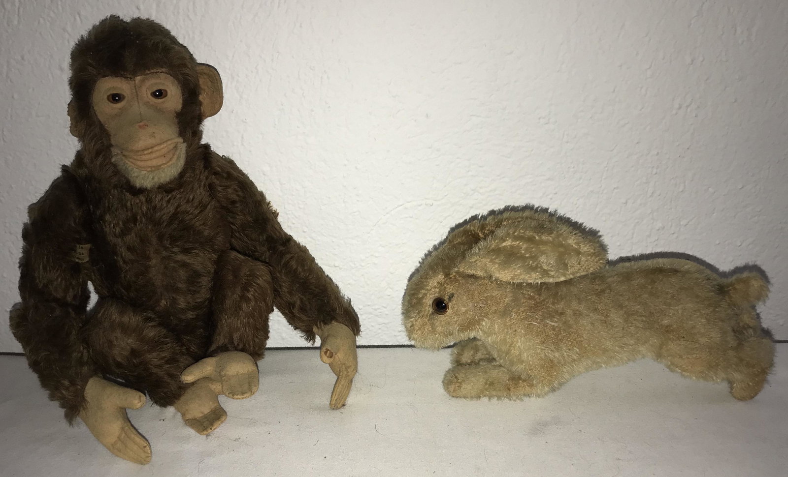 Steiff Rabbit AND Monkey (probably Jocko): Steiff mohair rabbit "Hoppy" (running), w/original ear button, shows mohair and wear throughout, felt on underside of ears shows deterioratiion, 5 1/4" T x 9 3/4" L D fully jointed mohair stuff toy mo