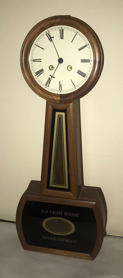 Reproduction Banjo Clock: Reproduction Howard style banjo clock, lower glass panel reads US Light House Establishment, mahogany case, round dial w/Roman numerals, base door opens down to pendulum w/key; 26 1/2" T x 10 1/2" W x
