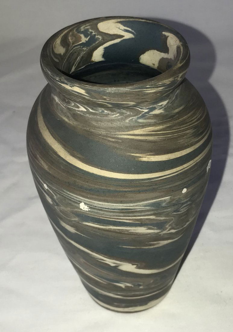 Niloak Art Pottery Vase: 20th century Niloak art pottery vase, multi-colored swirled design in blue, brown, cream w/impressed Niloak mark on base, tapered vasiform shape, 6" T x 3 1/2" diameter, 4 spots which appear to be pai