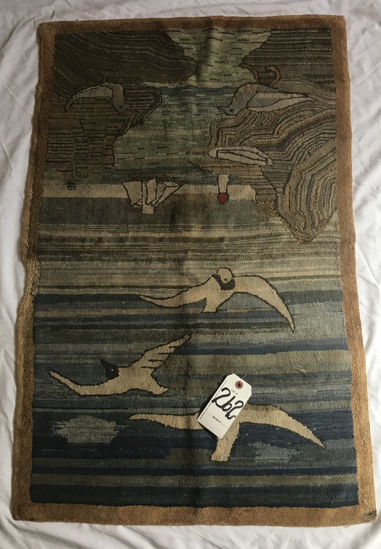 Coastal Scene Hooked Mat: Grenfell Labrador Industries decorative hooked mat, coastal scene w/seagulls, sky, water, sailing ship and lighthouse in blues, gray, brown and cream w/tan border, label reads hand made in Newfoundlan