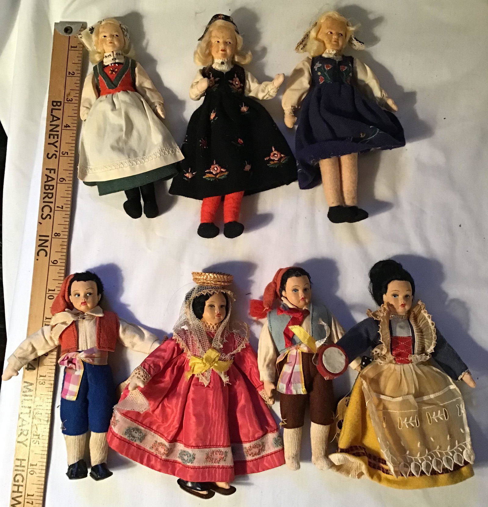 Grouping of 7 Dolls: Grouping of 7 dolls, all w/cloth (cotton) stuffed bodies, detailed handpainted faces; 4 are in Mediterranean dress-2 women-2 men, 6 3/4" T AND 3 ladies all w/blonde hair in Bavarian/German garb, legs 