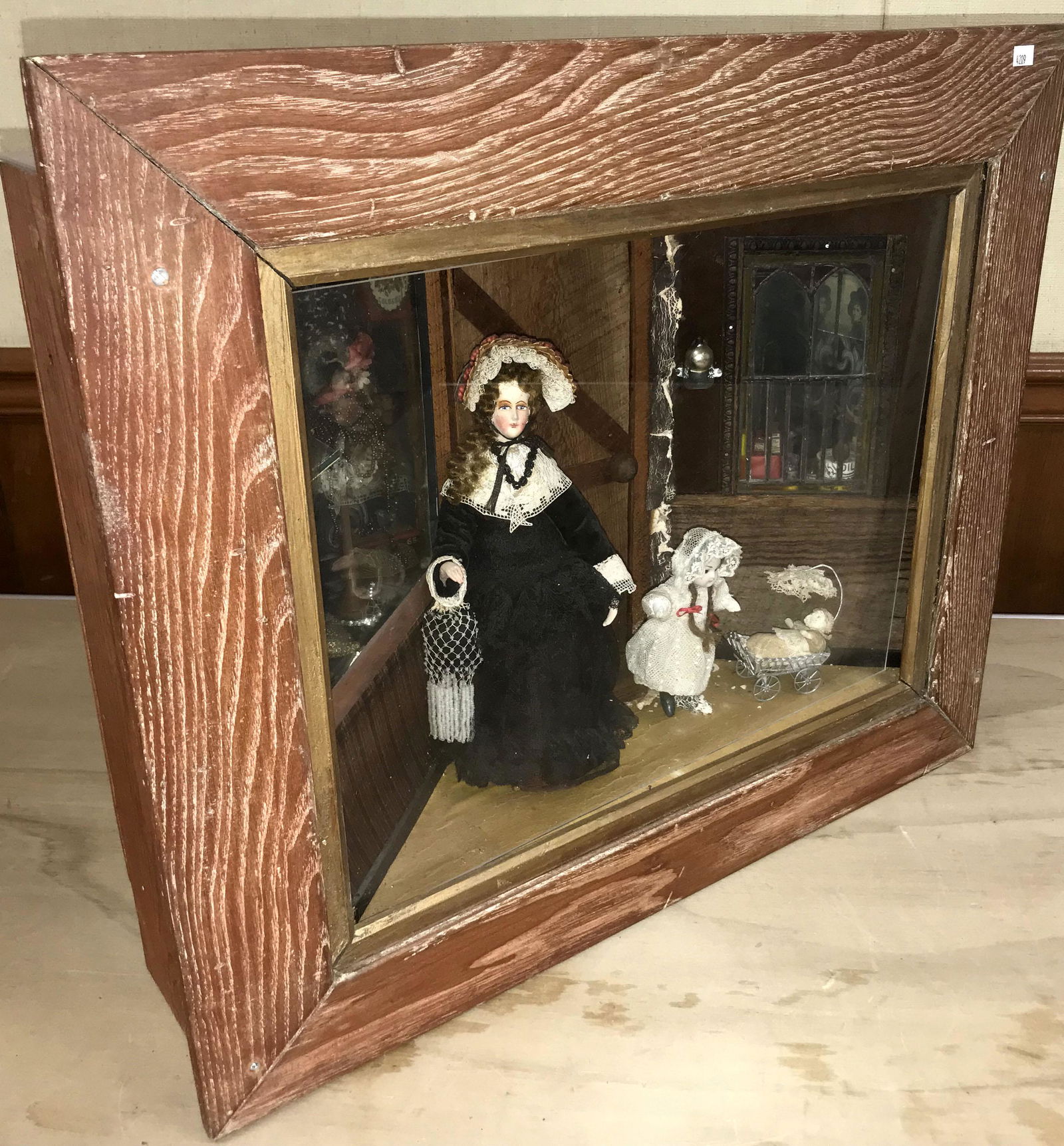 Vintage Vignette: Vintage vignette interior scene w/lady doll together w/child pushing a doll coach, numerous older decorations: leaves, bottles, etc, contained in a pine case w/oak frame, IMPERFECTIONS to various cont