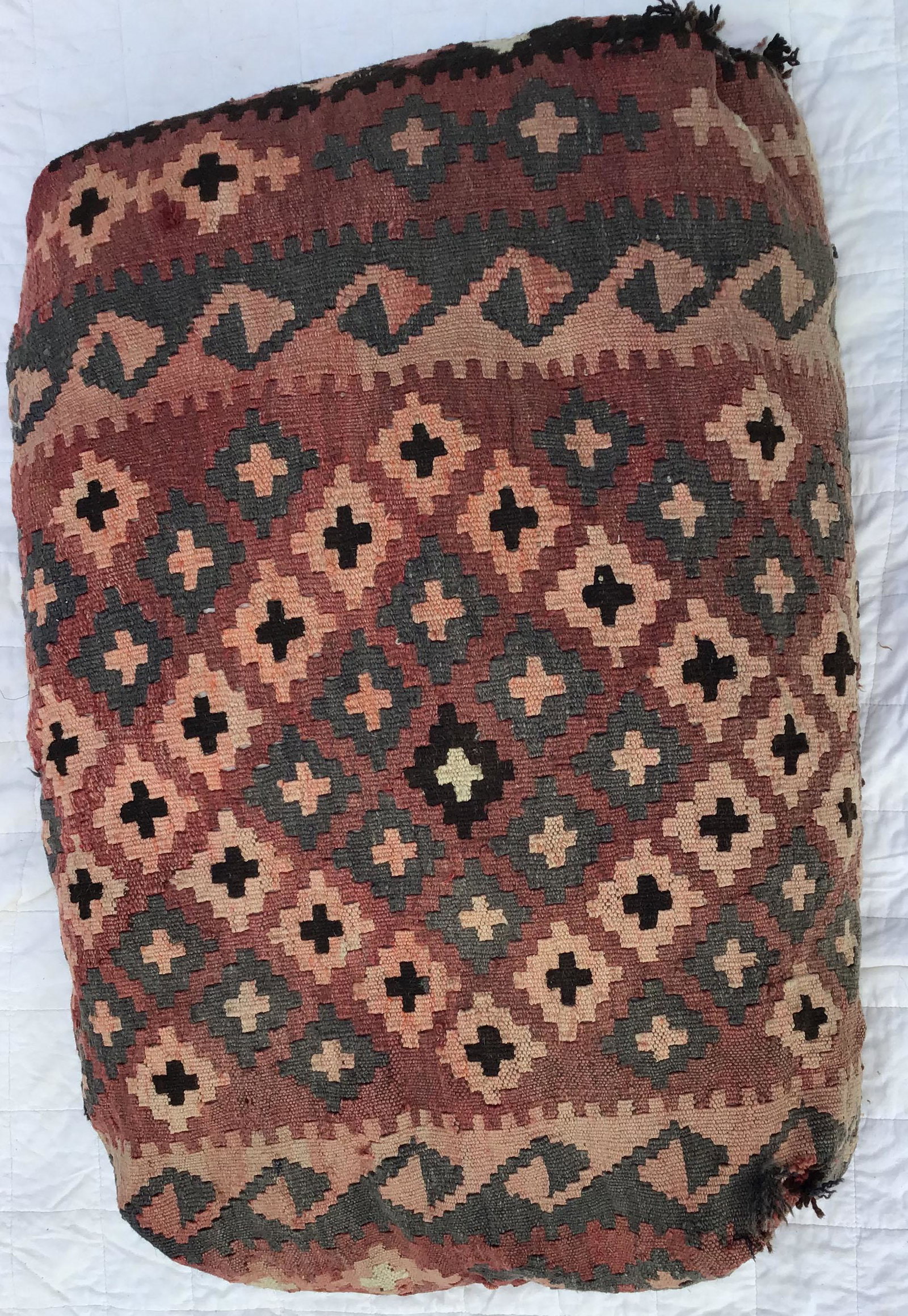 Cushion Made from Kilim Carpet: Single cushion made from Kilim rug, browns/orange, some fraying, thread separations, one side faded, holes visible, 20" x 28"