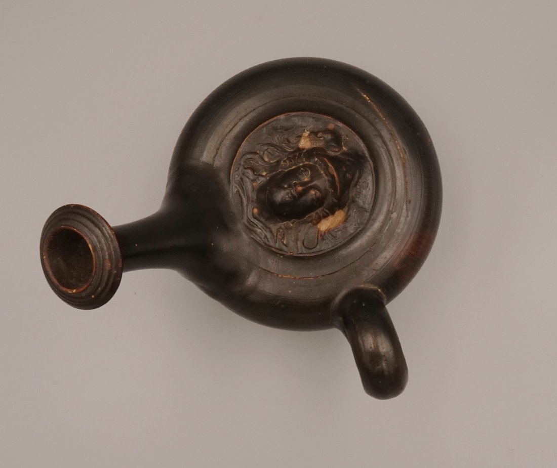 ANCIENT GREEK BLACKWARE ATHENA OIL LAMP FILLER GUTTOS: Very Early Greek(third century) ceramic guttus (also guttos) used to pour oil into oil-burning lamps. The vessel rests upon a concave ringed foot with a discoid body covered in dozens of fine vertical