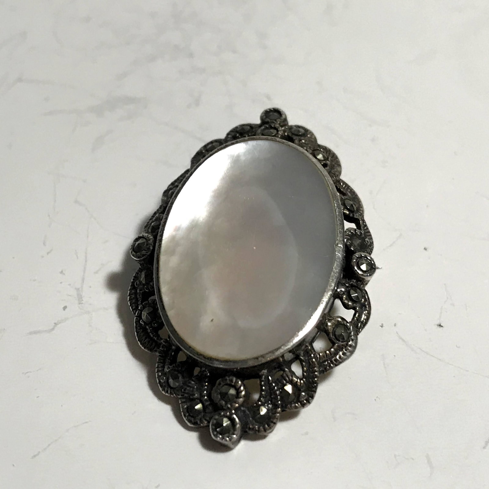 Vintage Marcasite Pearl Sterling silver Brooch: Vintage Marcasite Mother of Pearl Sterling silver Brooch Please view all photos as they are part of the description and condition of this Item, Feel free to contact me with questions or picture reques