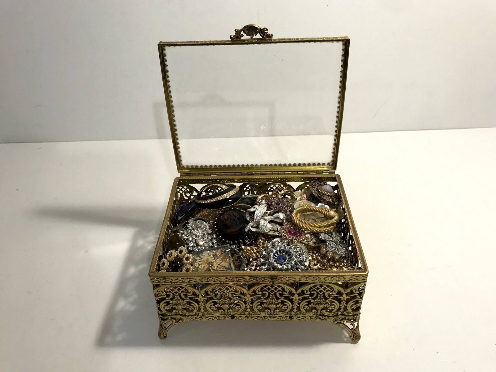 Vintage Brass Filigree Jewelry Box chest Casket beveled: Vintage Brass Filigree Jewelry Box chest Casket beveled glass Loaded with Over 50 Quality Brooches 6 1/2 X 5 1/4 X 3 3/4 Great Deal!!! Please view all photos as they are part of the description and co