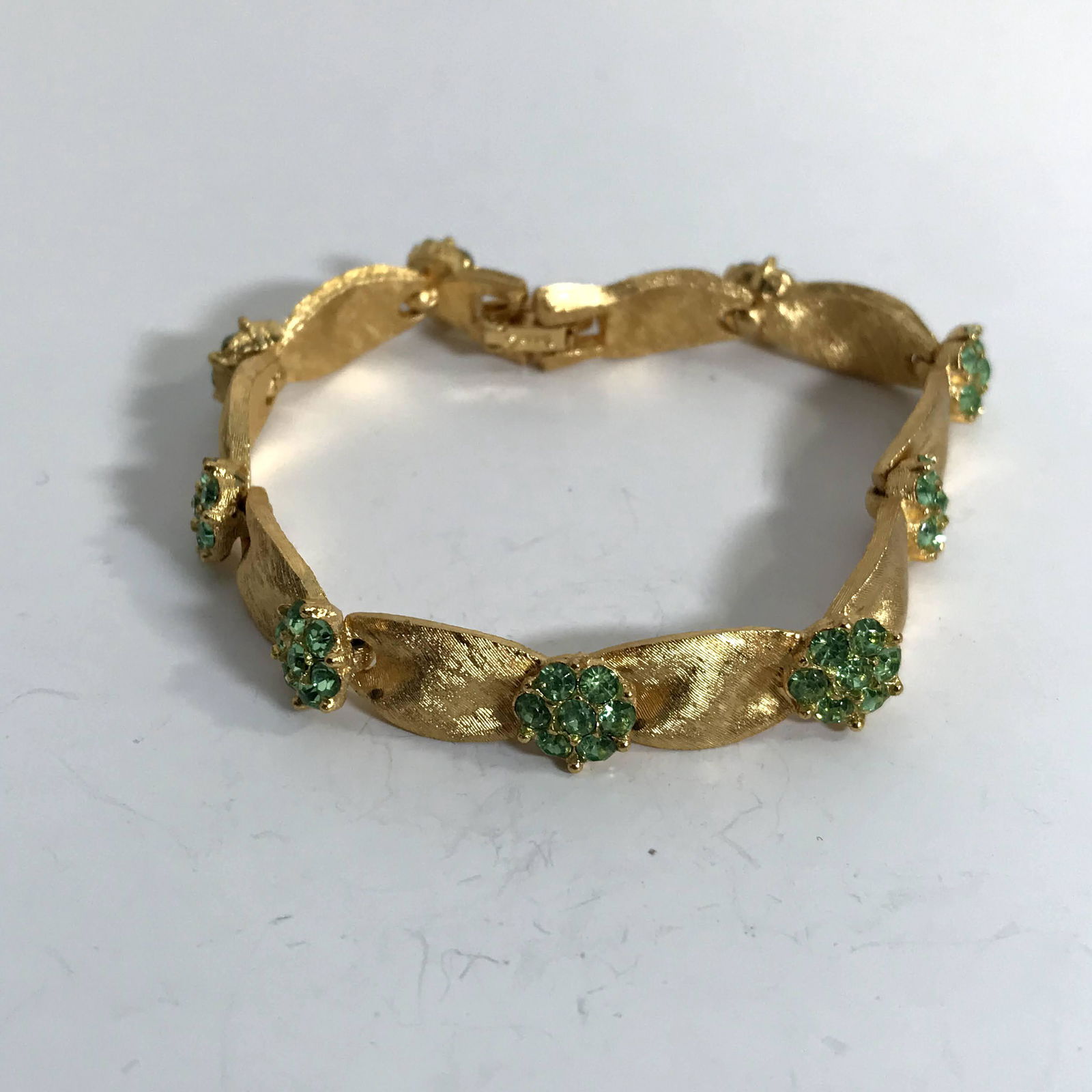 Vintage Trifari Bracelet Gold Tone Ribbon Design Green: Vintage Trifari Bracelet Gold Tone Ribbon Design Pink Rhinestone Flowers, measures 7” long, marked Trifari on the clasp, minor wear, looks good Please view all photos as they are part of the des