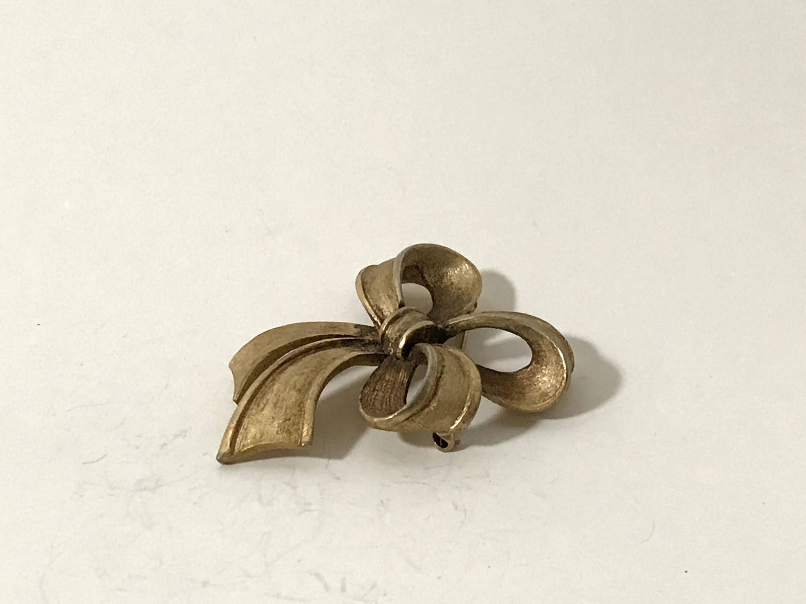 Vintage Gold Tone Textured Bow Brooch Signed Trifari: Vintage Gold Tone Textured Bow Brooch Signed Trifari 2 1/2" Please view all photos as they are part of the description and condition of this Item, Feel free to contact me with questions or picture req