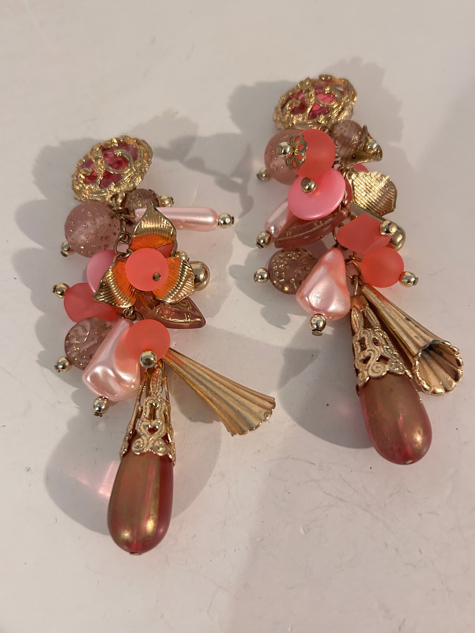 Vintage clip-on earrings, characterized by their ornate floral design and likely originating from: Vintage clip-on earrings, characterized by their ornate floral design and likely originating from the mid-20th century, possibly the 1940s or 1950s. Please view all photos as they are part of the desc