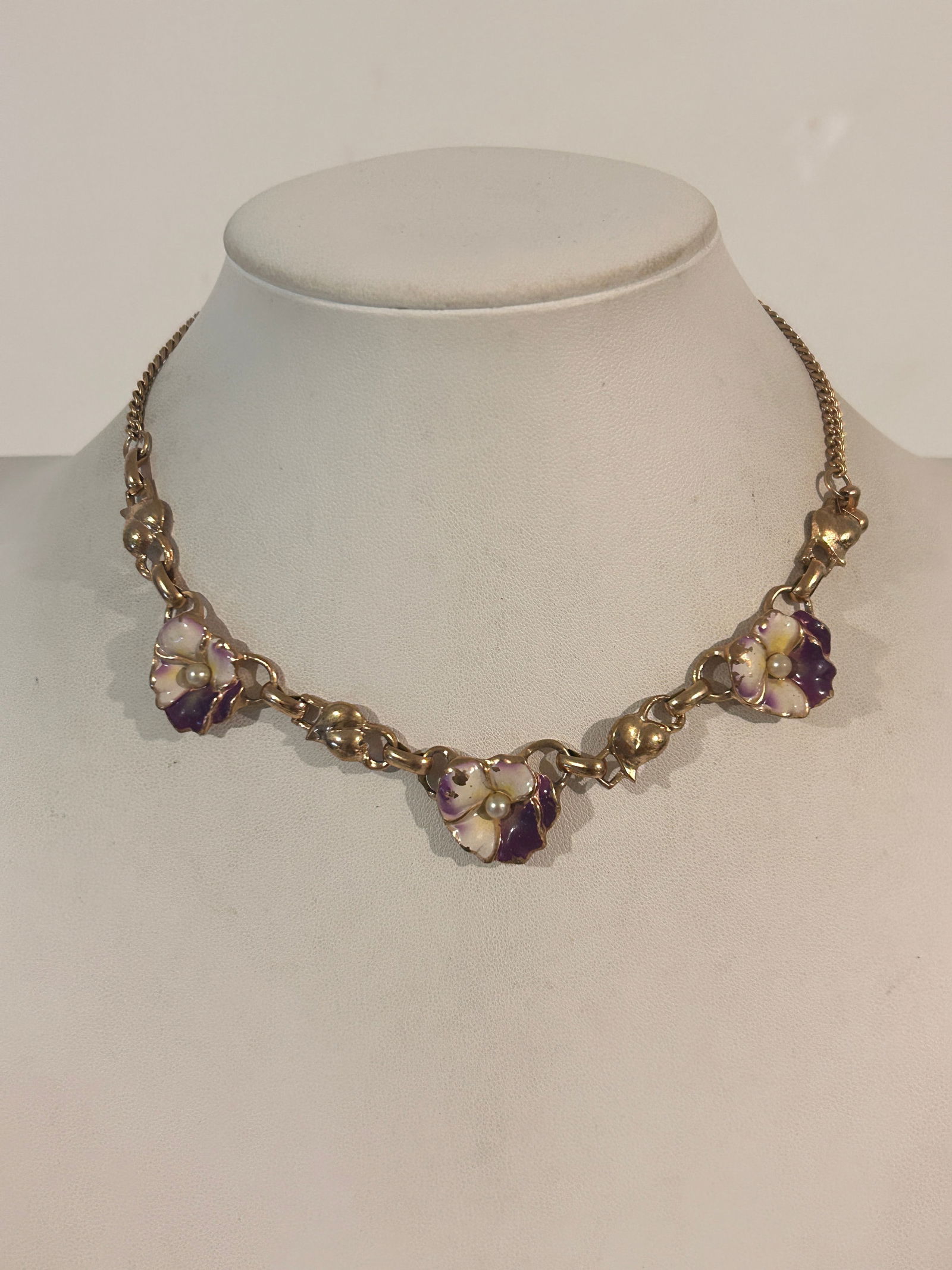 Vintage gold-tone metal link necklace featuring purple and white enamel pansy flower links with faux: Vintage gold-tone metal link necklace featuring purple and white enamel pansy flower links with faux pearl centers 14" Please view all photos as they are part of the description and condition of this