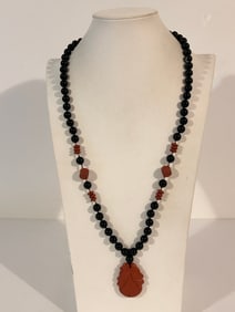 Vintage black onyx beaded necklace with a carved coral Shou Xin (longevity Buddha) pendant and 14k
