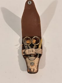 vintage-style personal grooming or manicure kit in a leather pouch, possibly a travel set