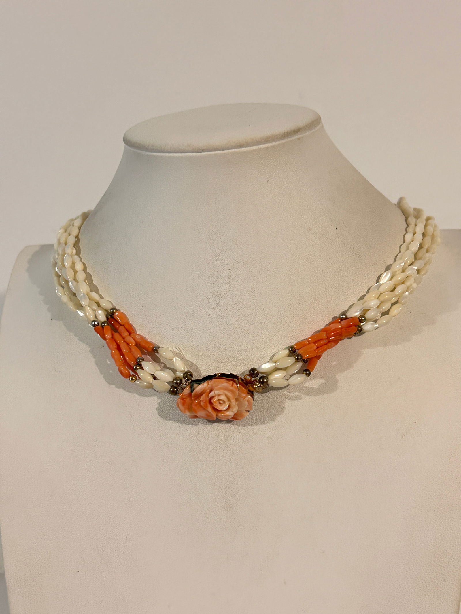 Vintage multi-strand necklace featuring carved mother-of-pearl rice beads and a carved coral rose: Vintage multi-strand necklace featuring carved mother-of-pearl rice beads and a carved coral rose clasp with coral bead accents. Please view all photos as they are part of the description and conditio