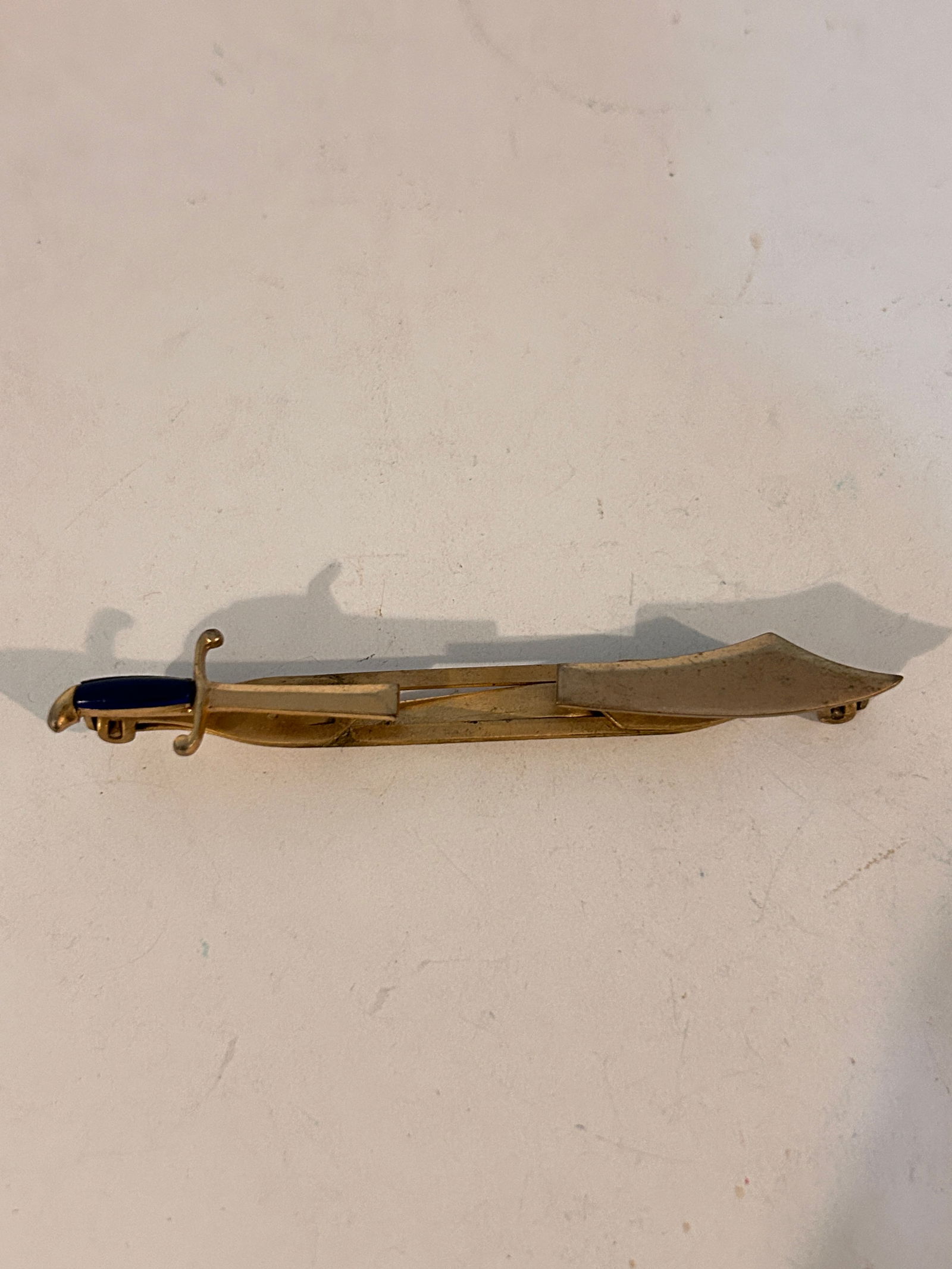 Vintage SWANK Combat Sword Tie Clip / Bar Blue Handle Gold Tone: Vintage SWANK Combat Sword Tie Clip / Bar Blue Handle Gold Tone Please view all photos as they are part of the description and condition of this Item, Feel free to contact me with questions or picture