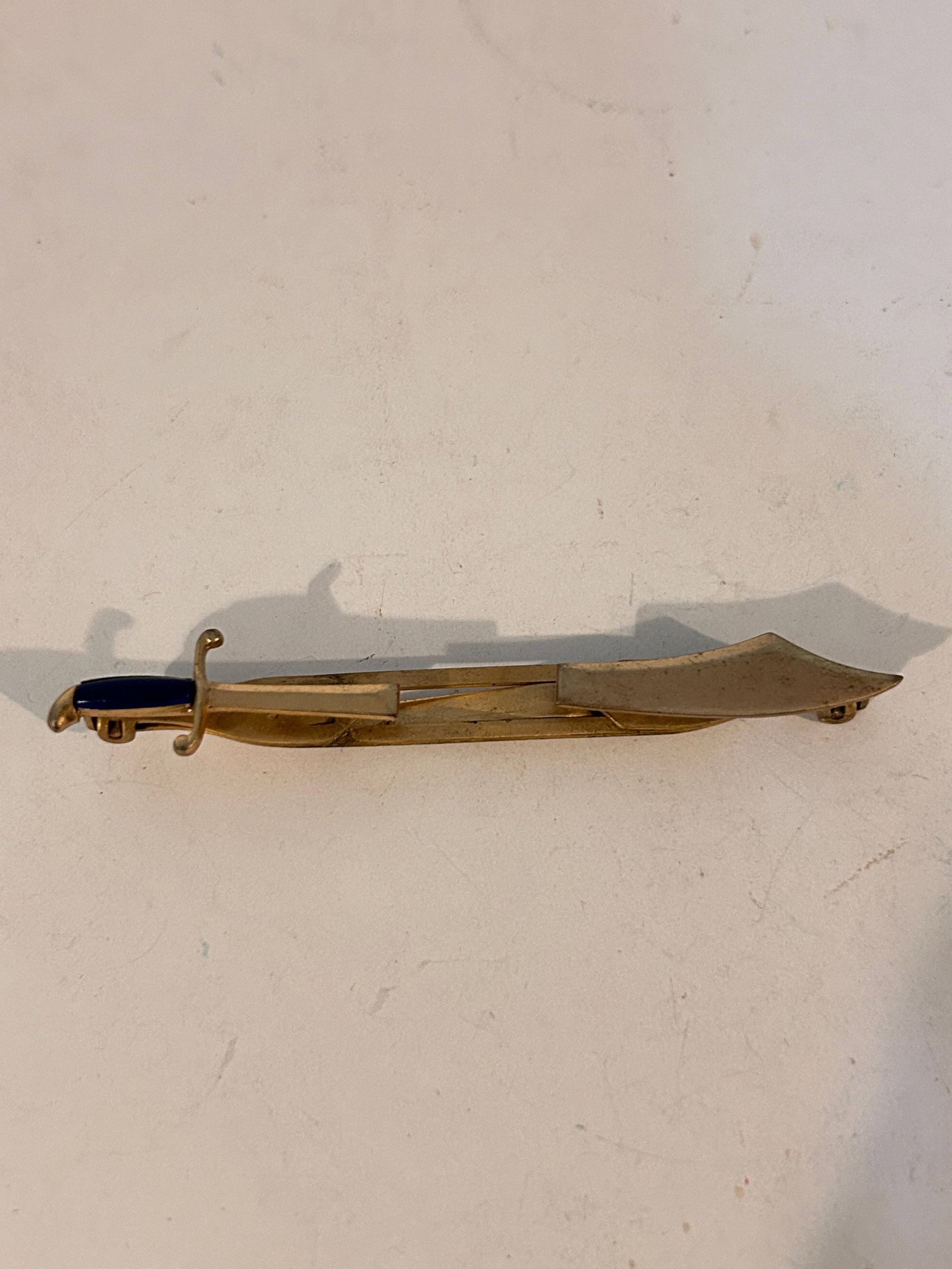 Vintage SWANK Combat Sword Tie Clip / Bar Blue Handle Gold Tone: Vintage SWANK Combat Sword Tie Clip / Bar Blue Handle Gold Tone Please view all photos as they are part of the description and condition of this Item, Feel free to contact me with questions or picture