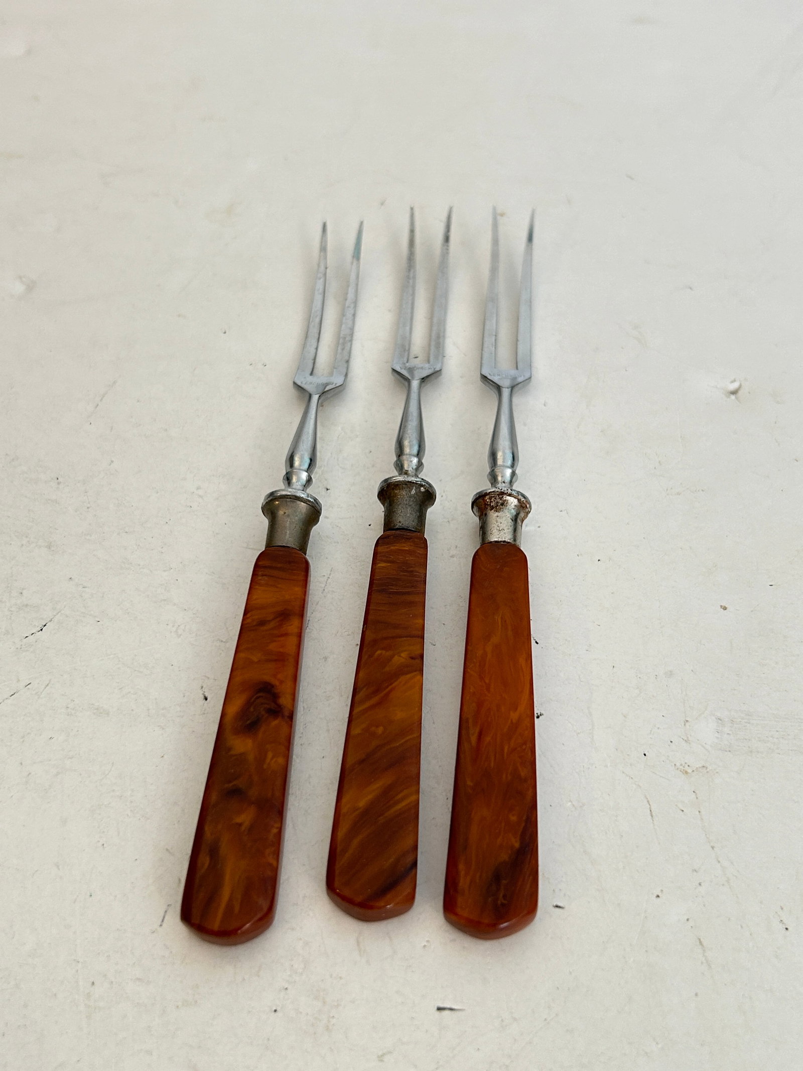 three vintage two-pronged forks marbled amber and brown Bakelite handles: three vintage two-pronged forks marbled amber and brown Bakelite handles Please view all photos as they are part of the description and condition of this Item, Feel free to contact me with questions o